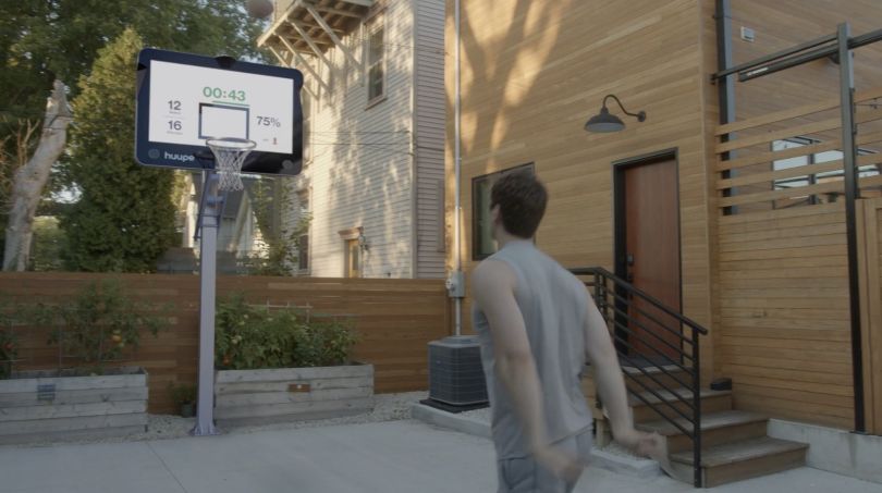 A person shooting a basketball on a Huupe smart hoop.