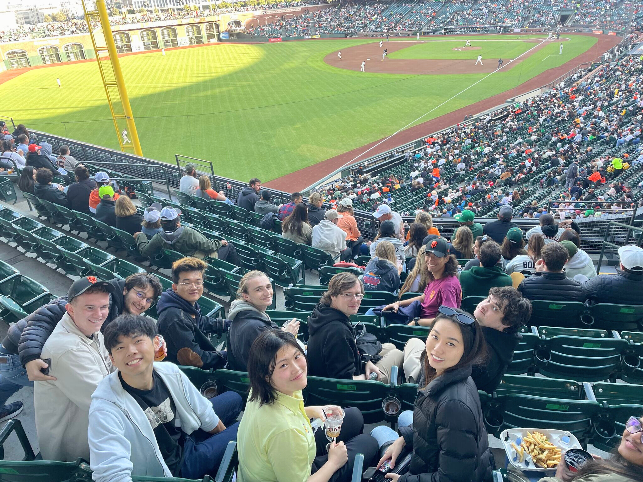2K grad program members from both the US and Dublin pose for a photo at a baseball game