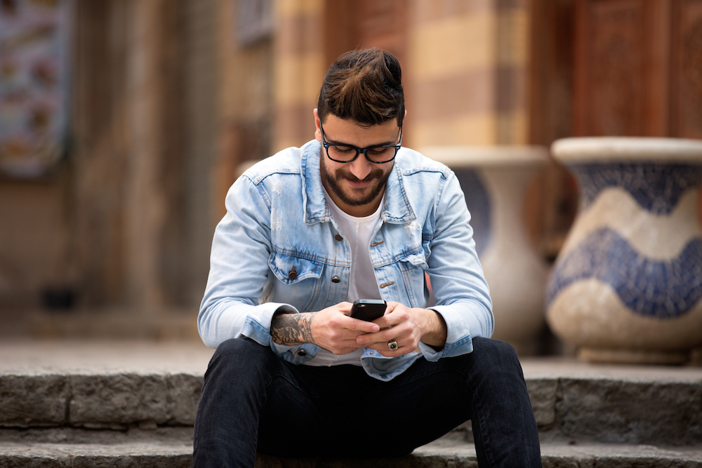 A man on his smartphone smiling