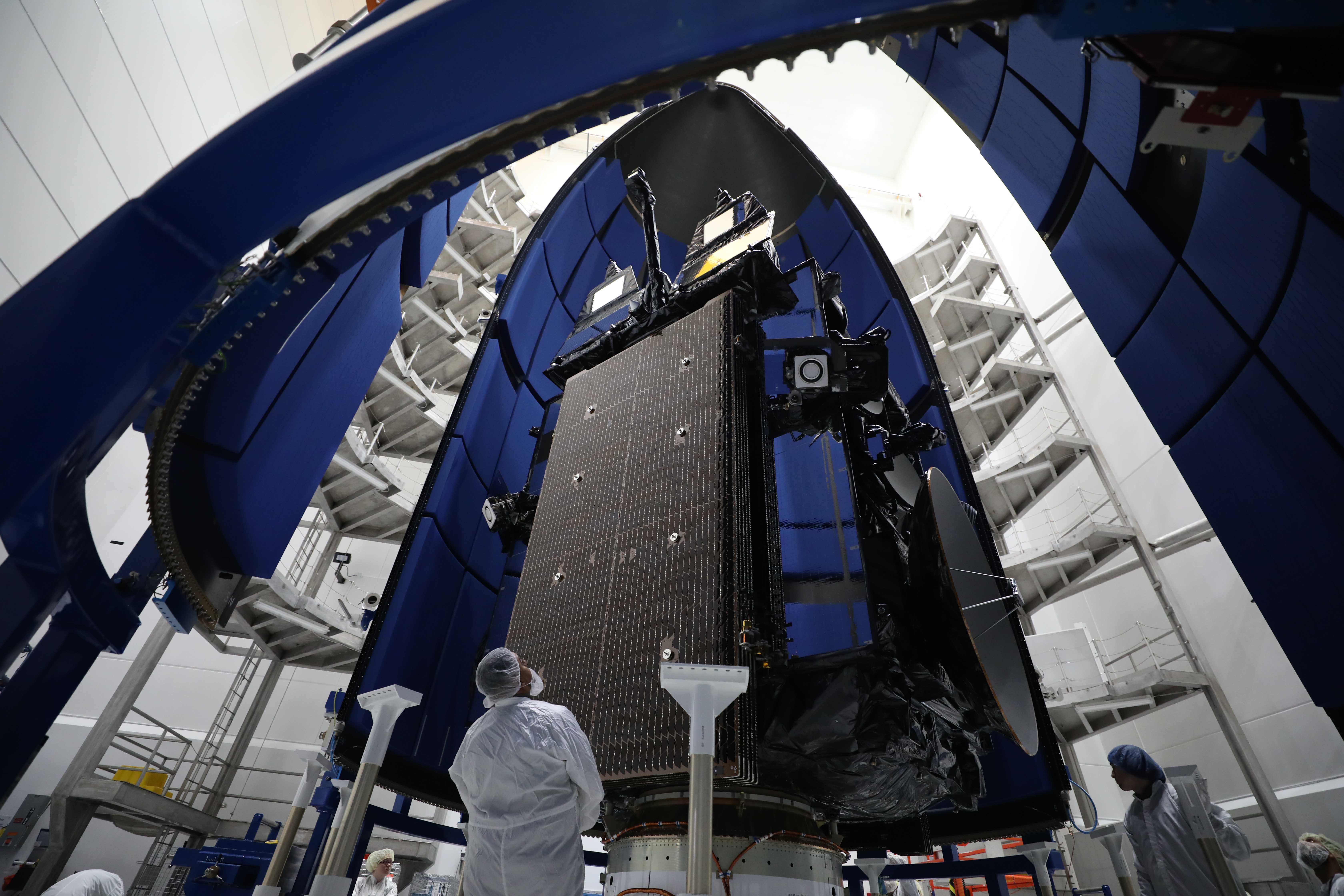 Aerospace Corporation Employees working on a satellite before launch.