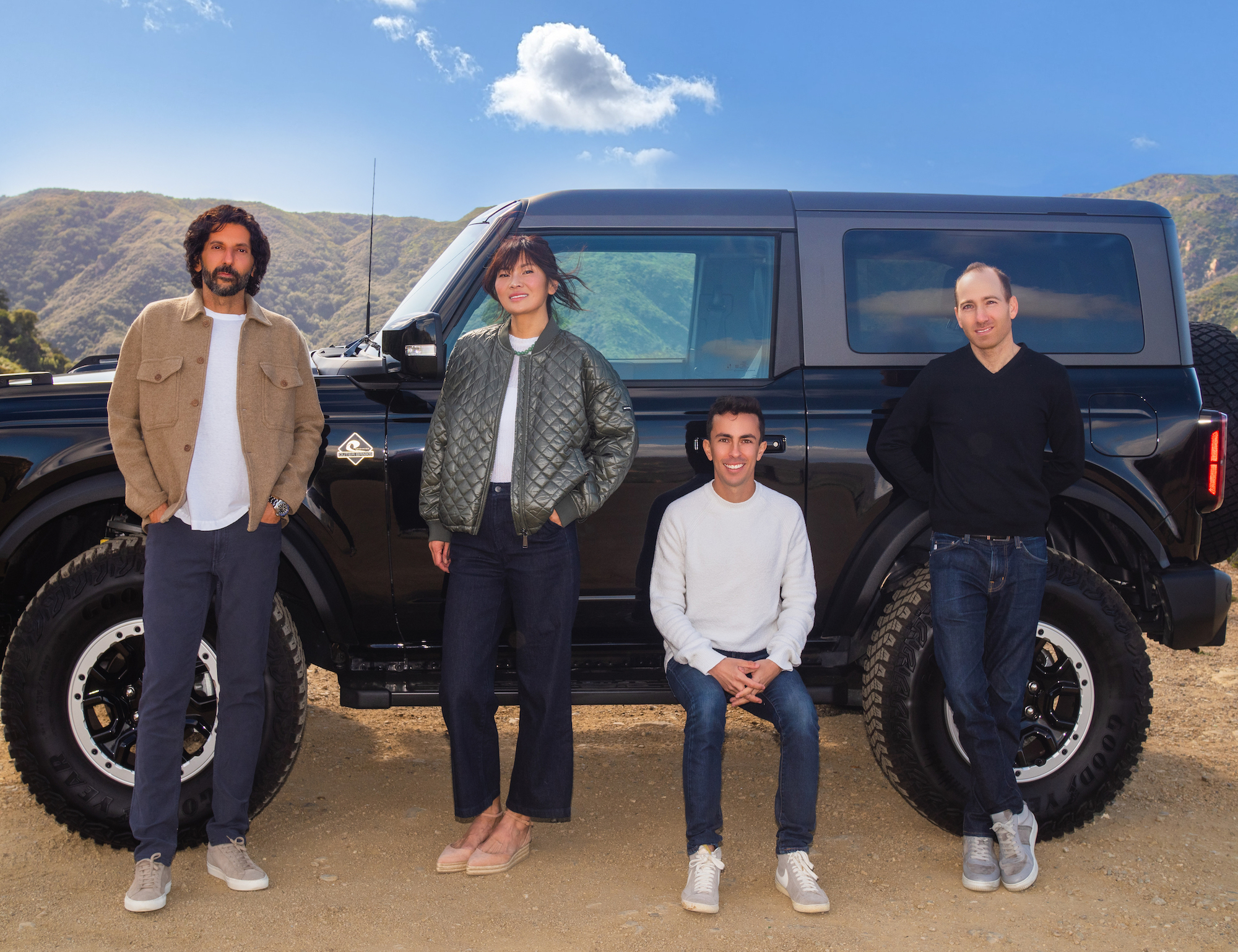 Caramel’s executive team pose together in front of an SUV.