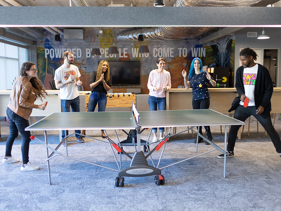 Members of the Core Digital Media team playing ping pong in the office
