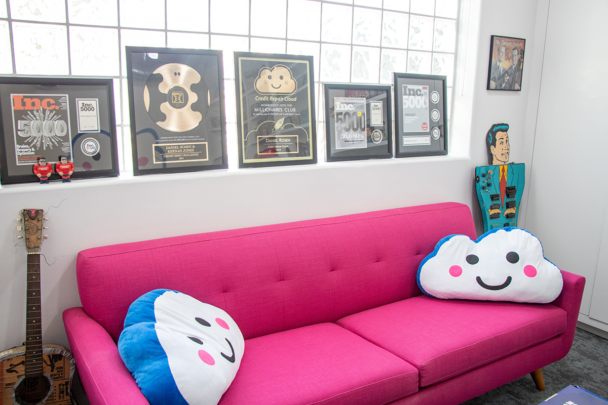 Couch in the Credit Repair Cloud office with the cloud logo pillows