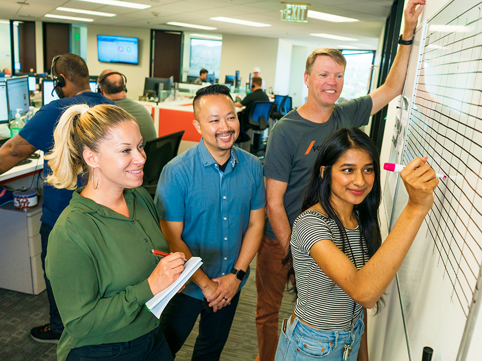 Forwardline employees work together on a whiteboard