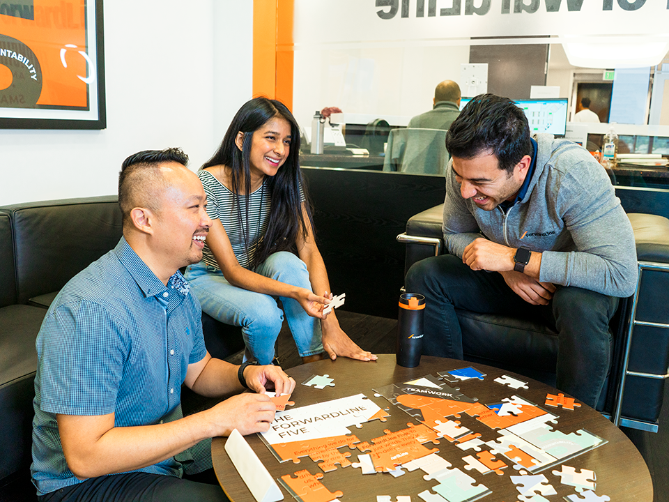 Forwardline coworkers work on a puzzle