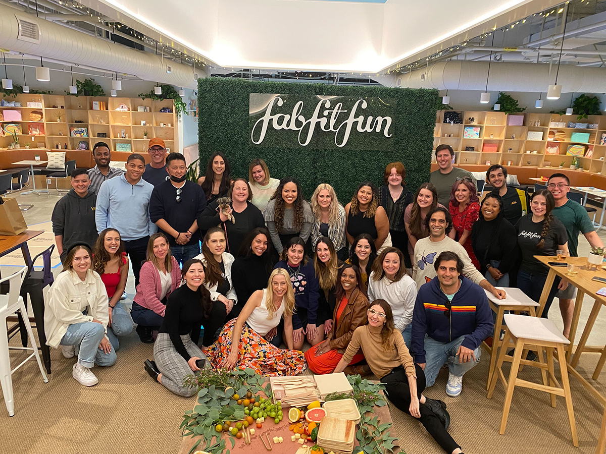 FabFitFun team group photo with a banner with the company logo printed on it