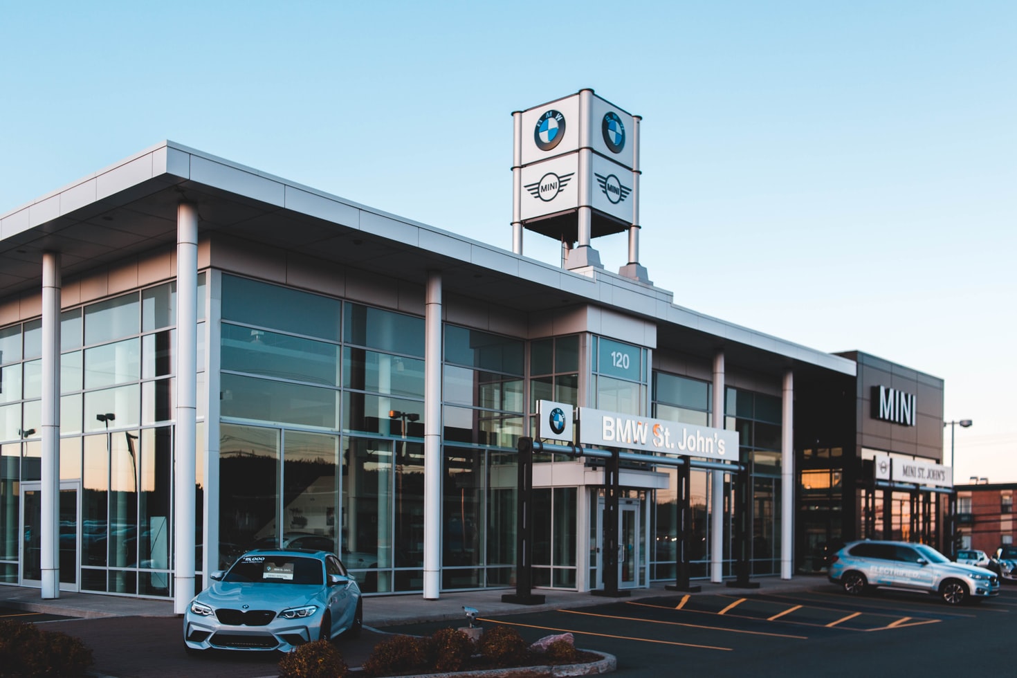 A BMW and Mini dealership showroom as seen from the parking lot.