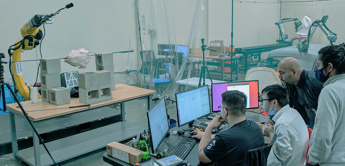 GrayMatter Robotics coworkers looking at a computer monitor in a testing facility