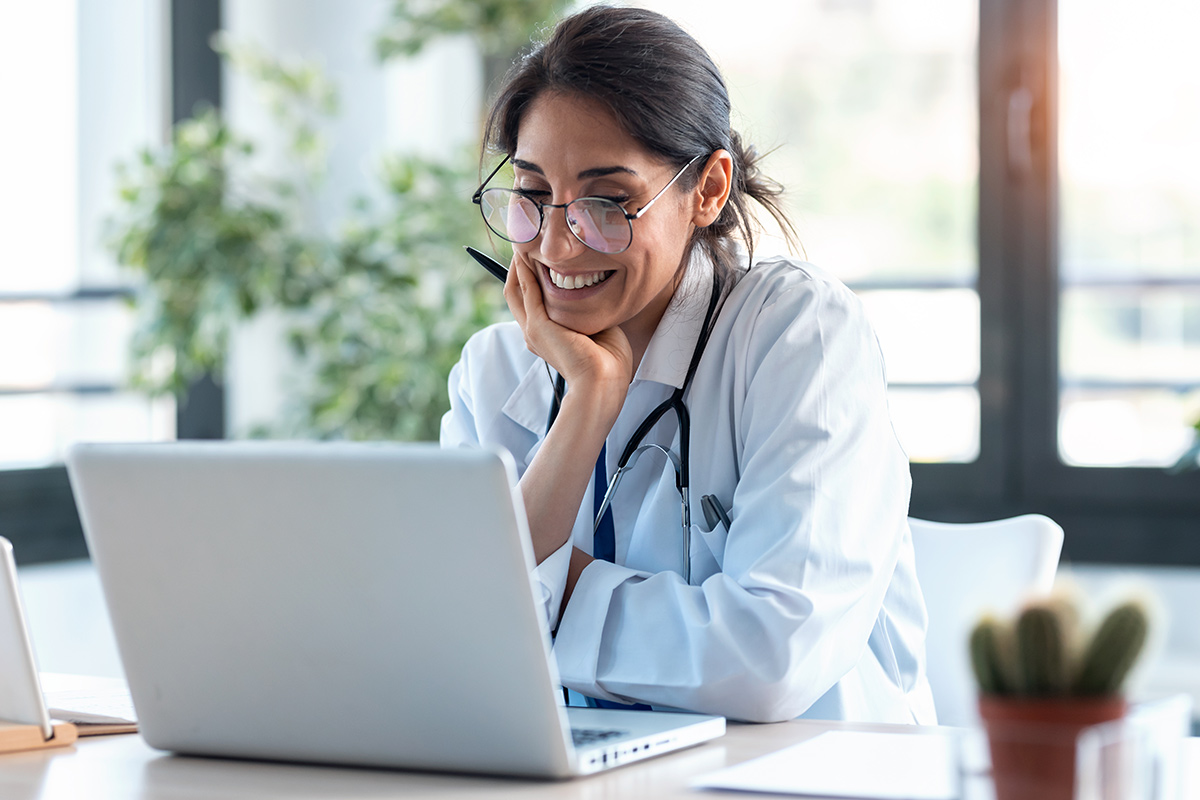 smiling female doctor working with her laptop for a virtual consultation