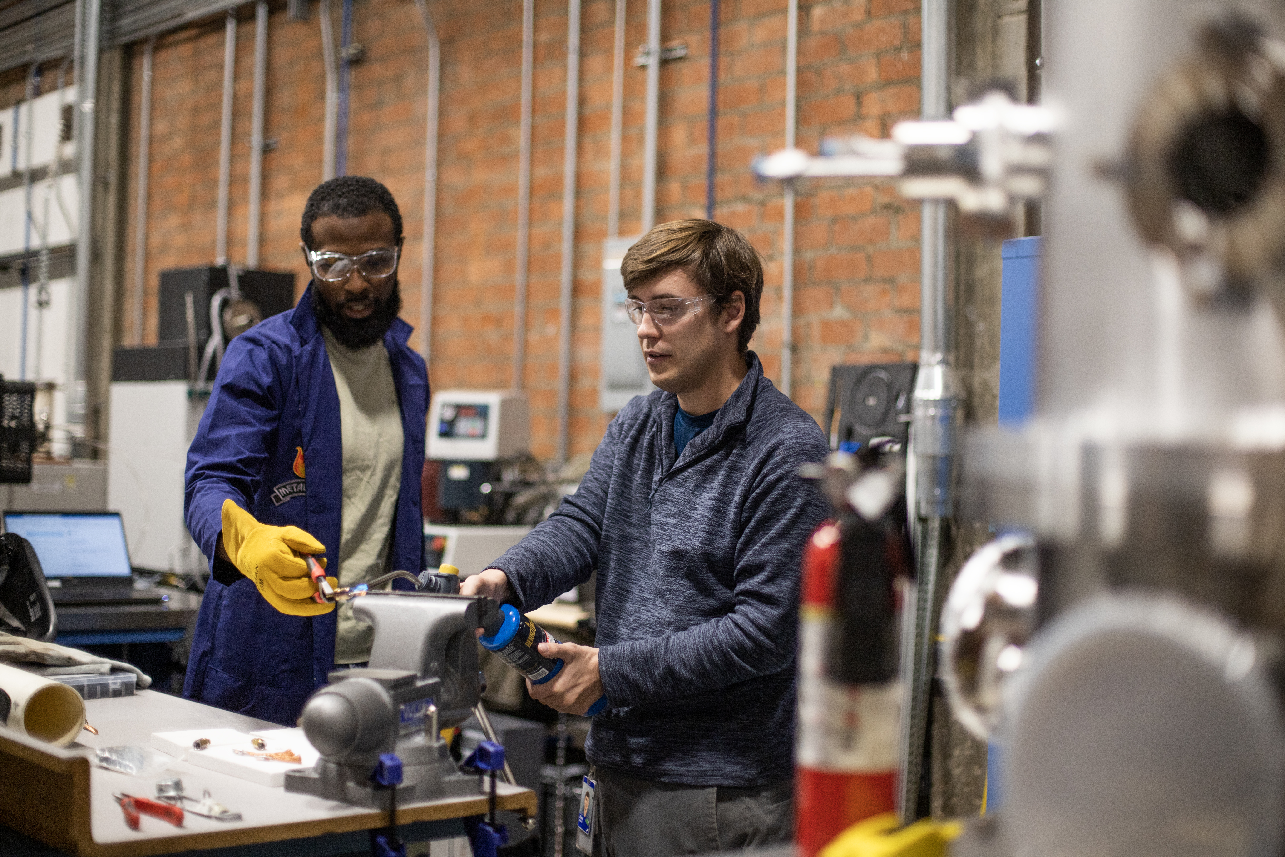 Honeybee Robotics employees working on machinery