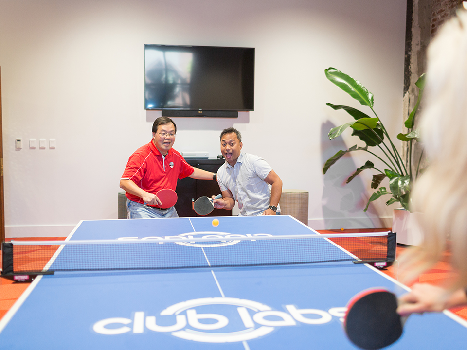 Fernan Fernandez plays ping-pong with a coworker
