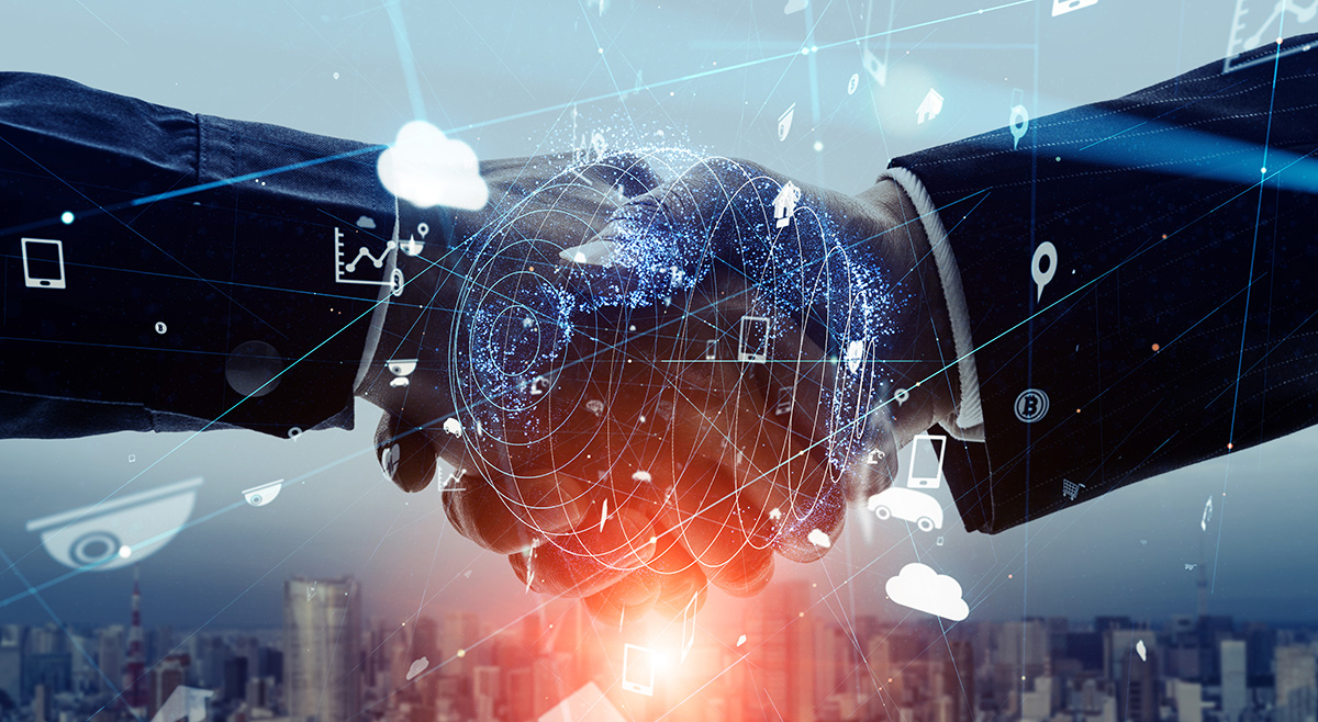 Close up of businessmen shaking hands with digital networking icons double exposed over their hands