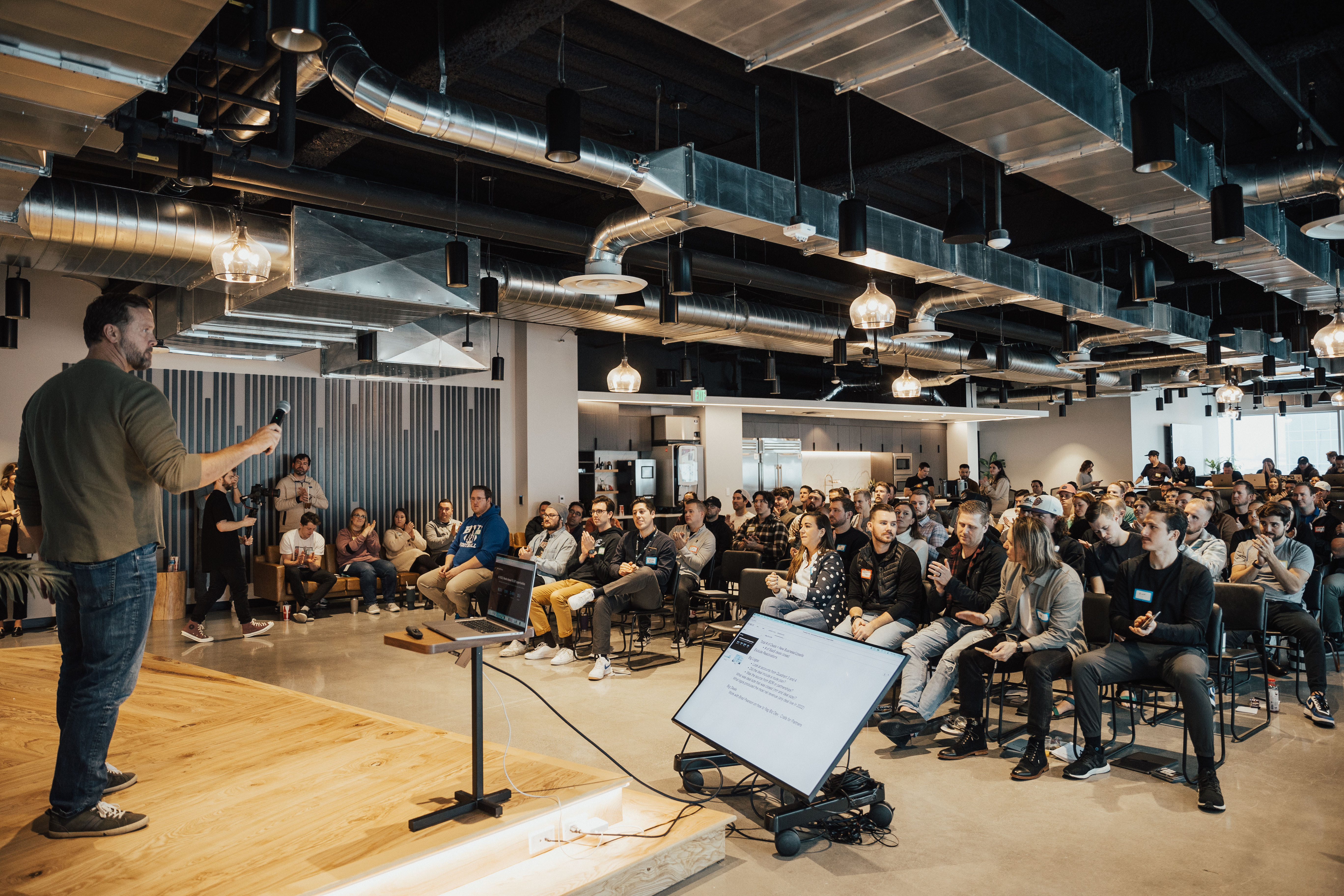 Leader standing on a stage looking out at audience of employees