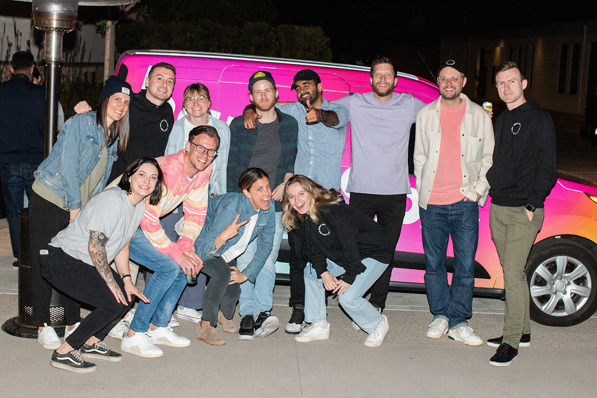 Repeat group photo in front of a hot pink van