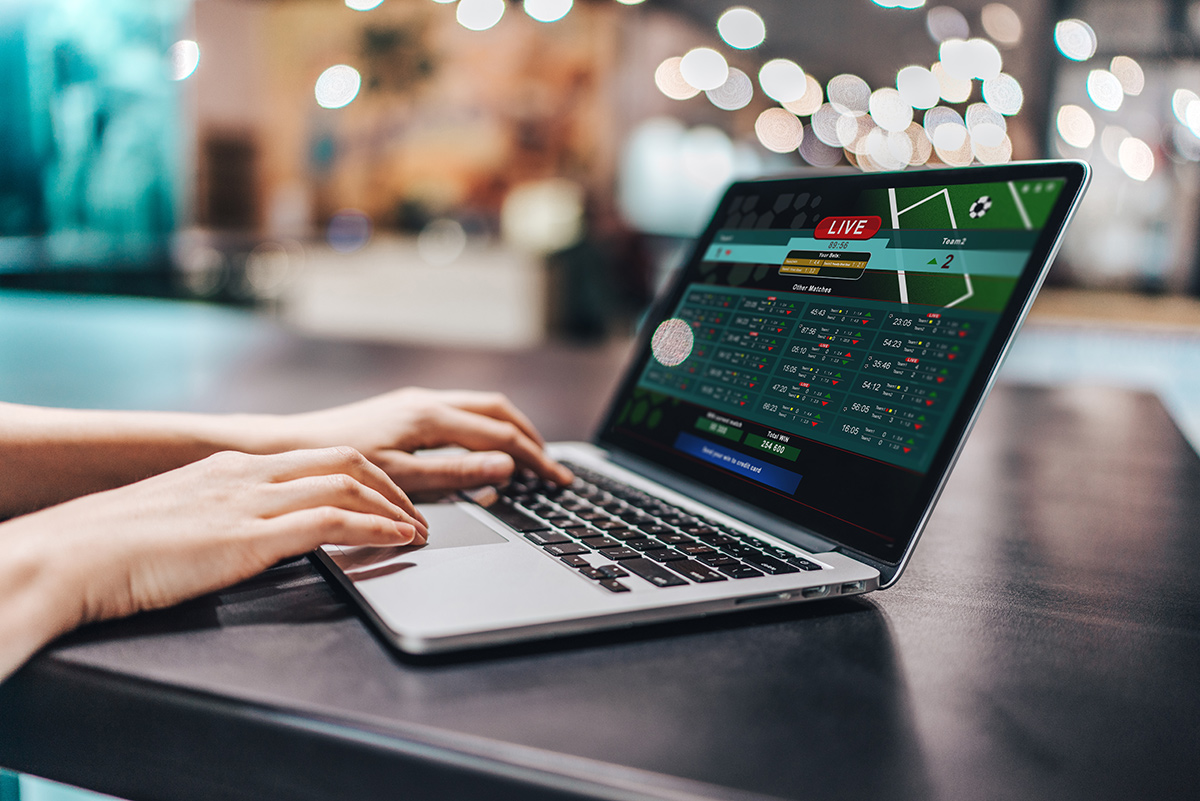 Close up shot of female hands using laptop to make bets online