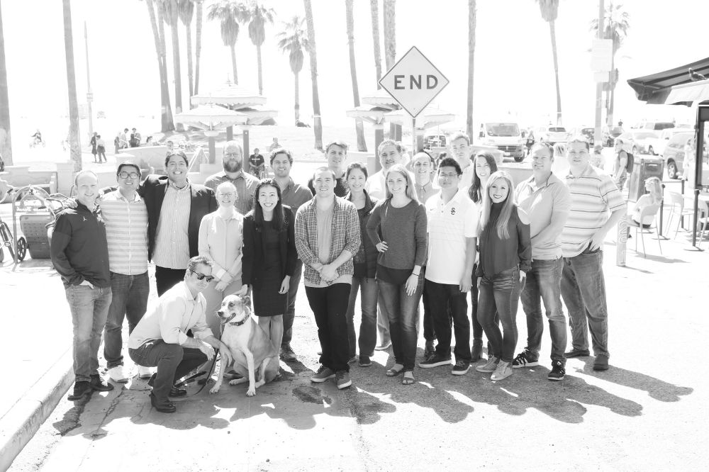 Black and white photo of Ylopo team outside by a street sign