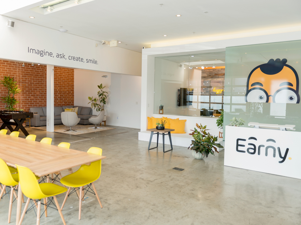 Inside Earny's beautiful office space, which features open space, brightly-colored furniture and a mural