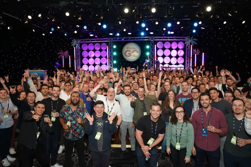 Large team celebrates with raised hands in a nightclub