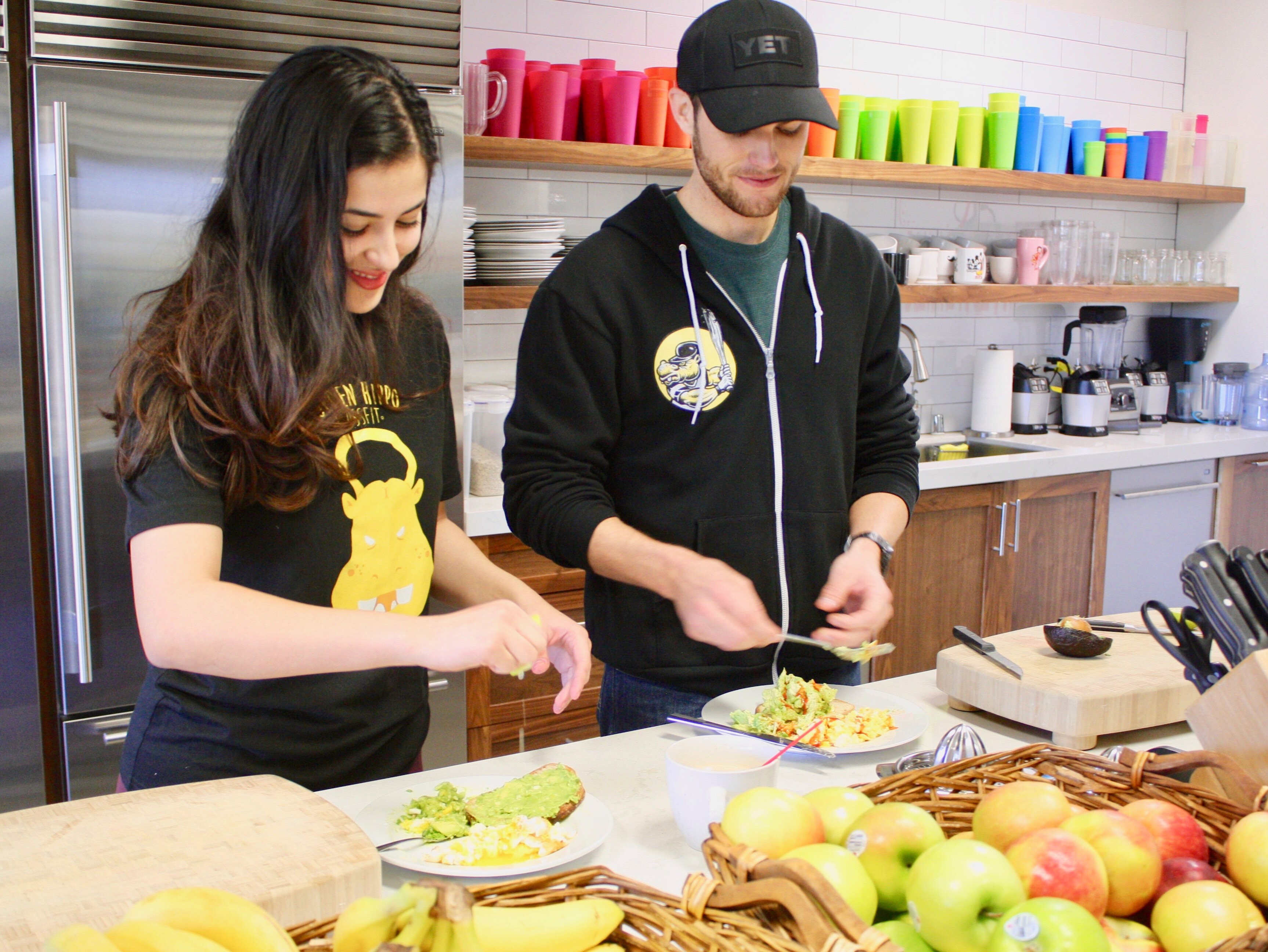 Two Golden Hippo team members cutting up fruit in a kitchen.