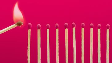 A line of matches, with another match moving toward a match at one end to light it.