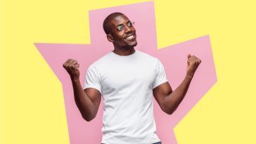 Man standing in front of abstract pink and yellow background, with fists upraised in excitement, ready to take on a new role