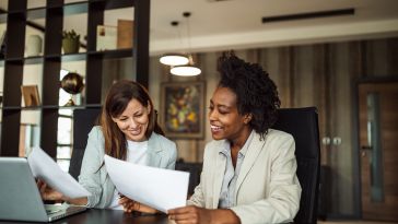 Two women discuss work together.