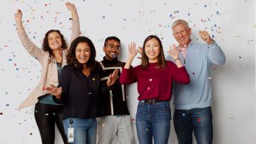 ServiceNow team members throwing confetti in the air