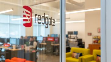 logo of redgate on glass door with view of office