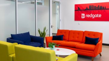 Redgate room with a red couch and red picture of the company logo and a cityscape outline.