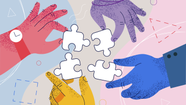 Hands of different colors putting puzzle pieces together