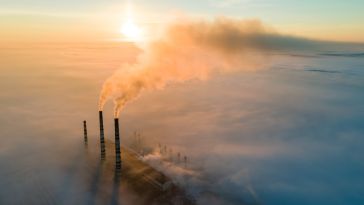 A smokestack emitting CO2 is pictured.